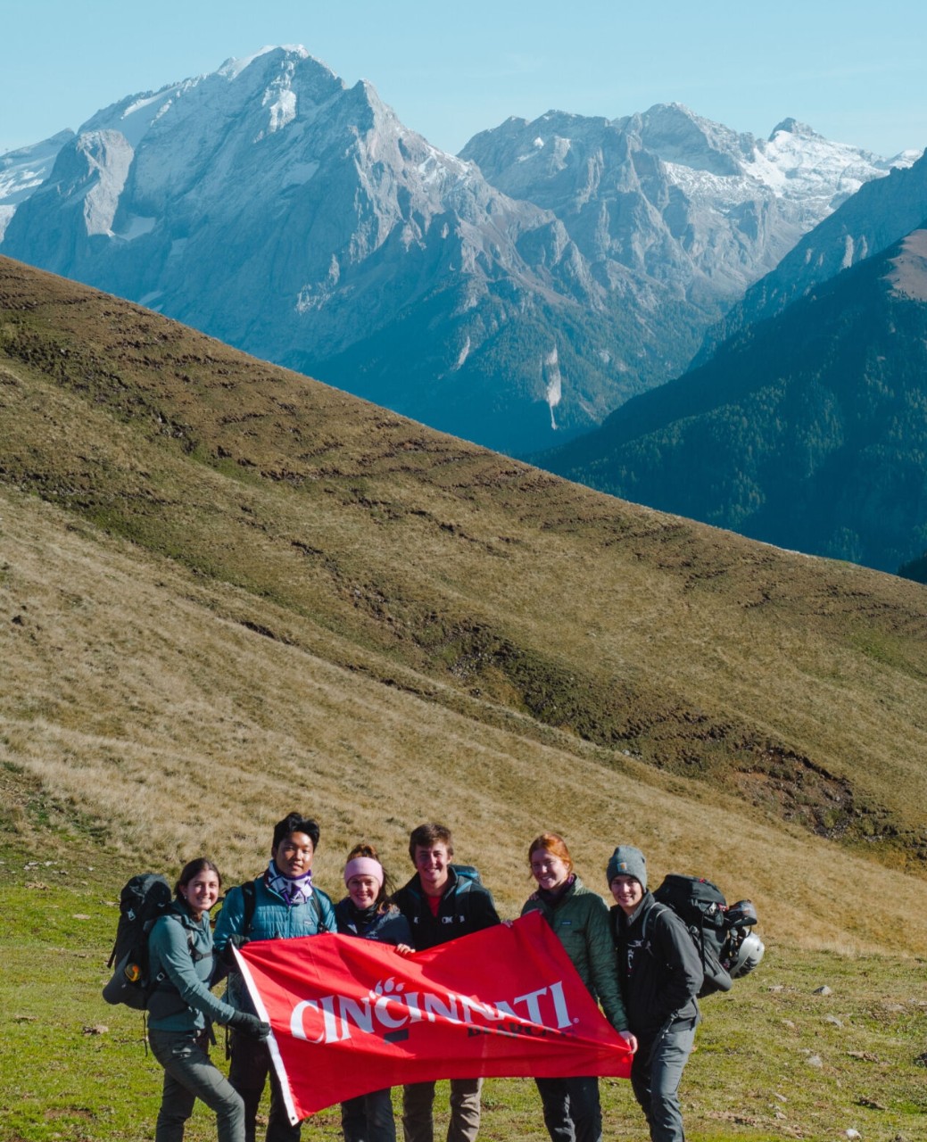 Madalyn Odea in Florence Italy holding UC banner with friends.
