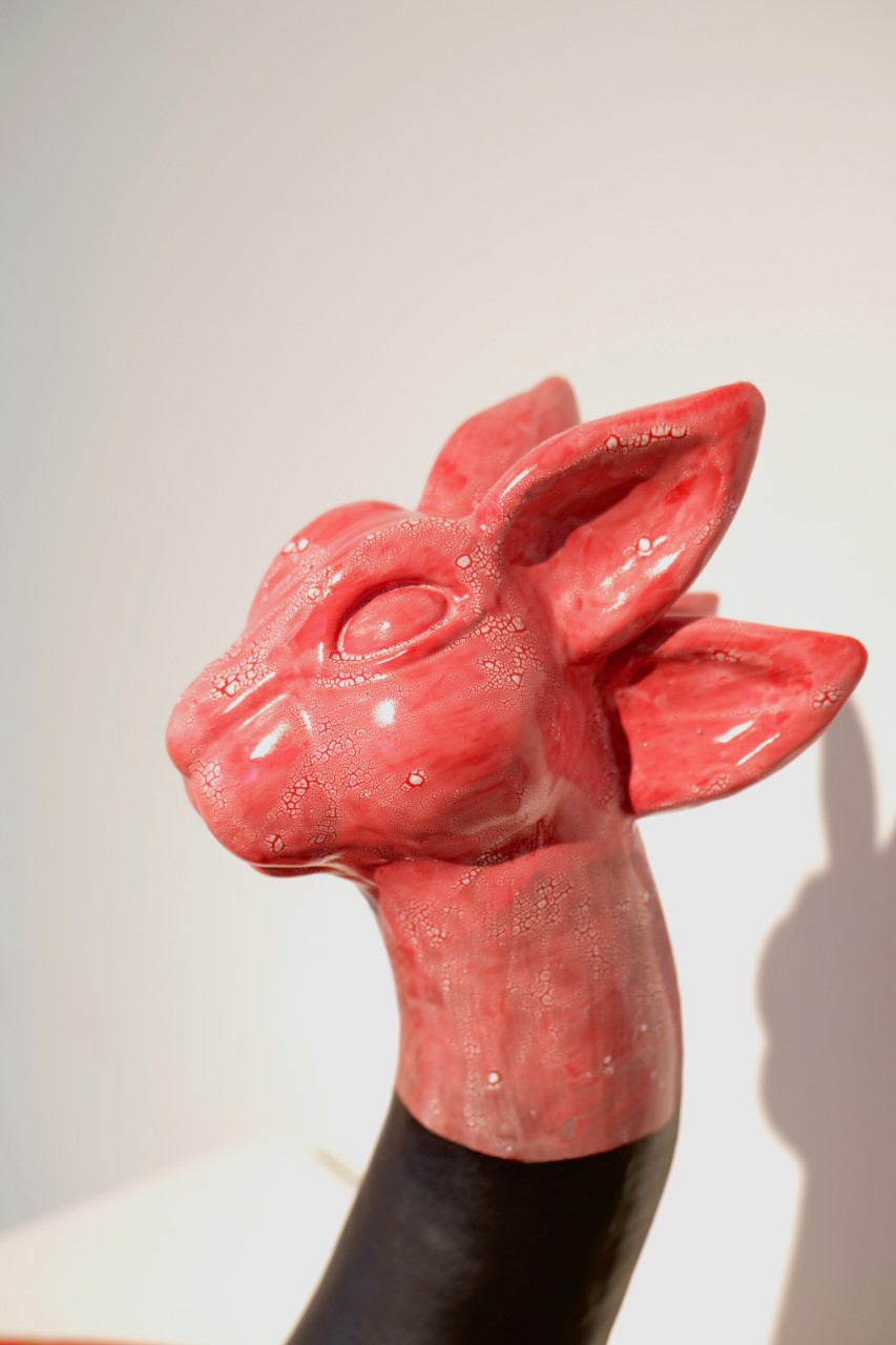 red glazed ceramic bunny head on top of red ceramic glazed slab