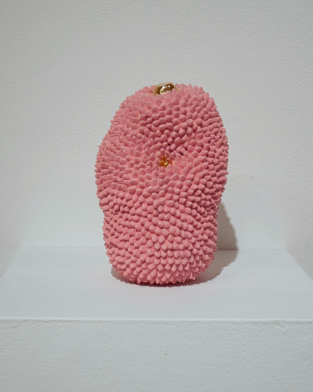 pink spiked vessel with gold lid