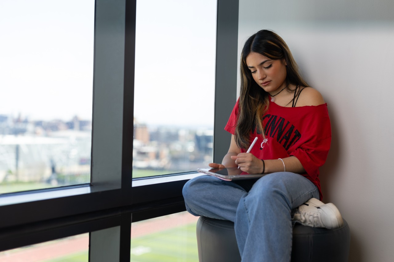 Student working on her tablet in the Calhoun common space. 