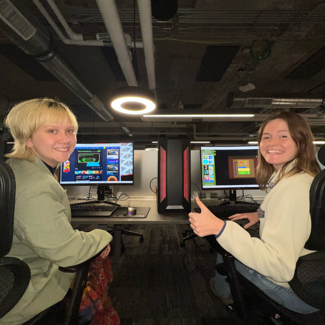 Mia and Kori at their respective desks at 1819